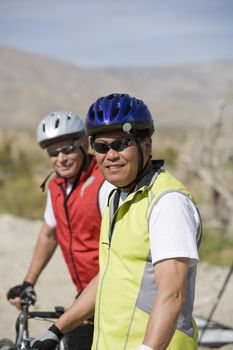 Portrait of a male cyclist smiling with friend in the background