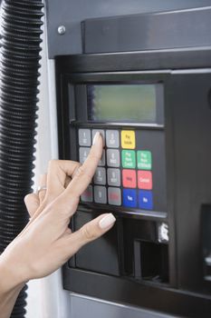 Close-up of woman's hand pressing number button on ATM machine