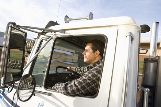 Portrait of mature male worker driving truck