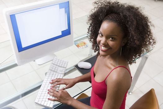 Portrait of a happy young woman working on computer