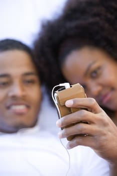 Young African American couple listening music through cell phone