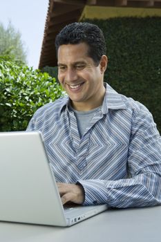 Happy mature man working on laptop