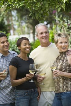 Diverse group of friends with glasses of wine looking away