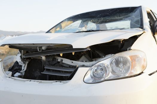 Closeup of a front end of wrecked car on desert highway