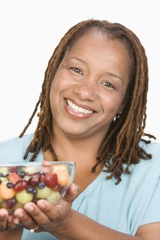 Portrait of Mid-adult overweight  woman holding bowl wit fruit salad and smiling close-up