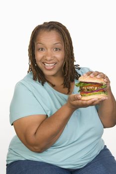 Portrait of Mid-adult overweight  woman holding big cheeseburger and smiling