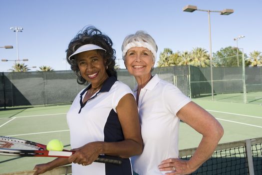 Portrait of happy senior female tennis players playing doubles
