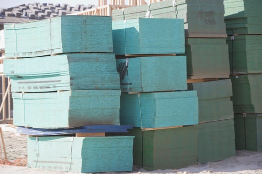 Stacked sheets of particle board at construction site