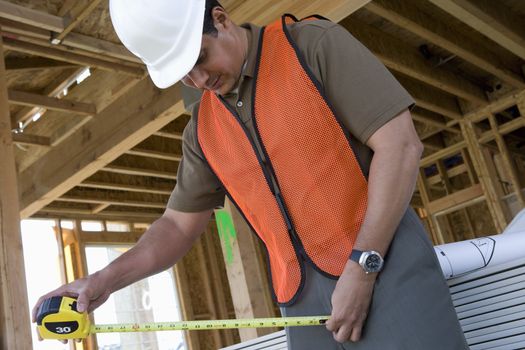 Architect using measure tape at construction site