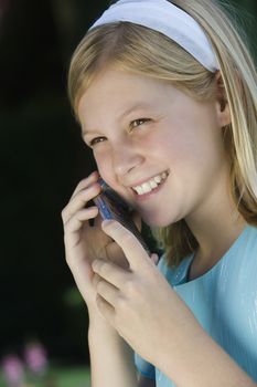 Happy teenage girl communicating on cell phone