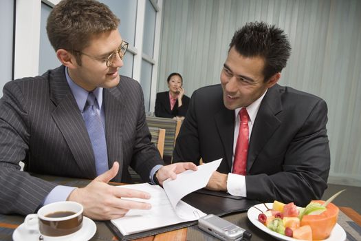 Happy multi ethnic business people discussing contract with woman in the background at restaurant