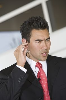 Handsome businessman communicating through earphones