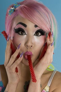 Portrait of young woman holding candy cane in her mouth