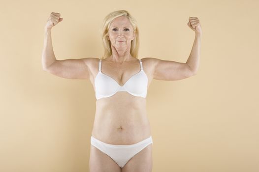 Mature woman flaunting her biceps and smiling