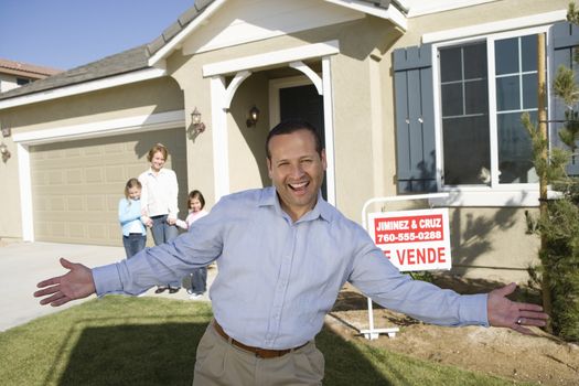 Portrait of excited man with family standing in front of house for sale