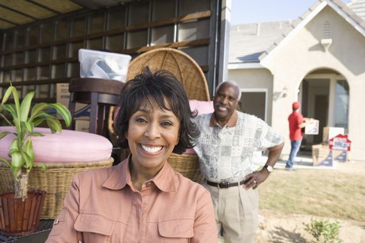 Portrait of happy African American couple at cargo vehicle moving into new house