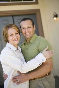 Portrait of happy mature couple in front of new house