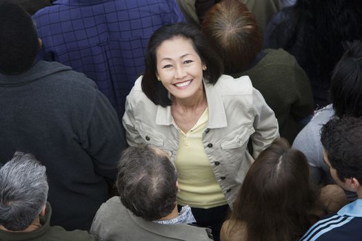 Portrait of happy Asian Chinese woman surrounded by people