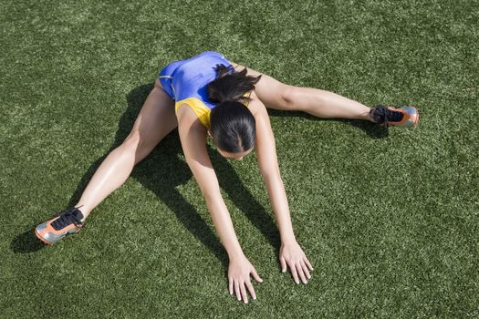 High angle view of female athlete exercising on field