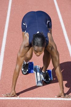 African American female runner in start up position
