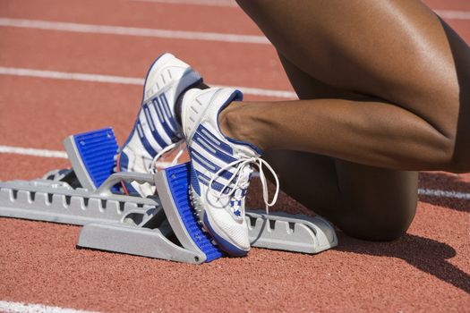 Cropped image of African American female runner on starting blocks
