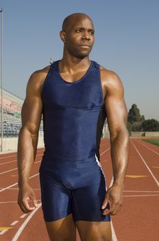 Confident African American male athlete on racetrack looking away