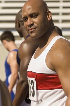 Portrait of confident African American male athlete with competitor in stadium