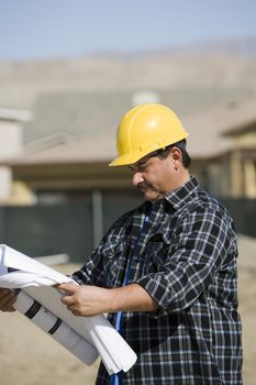 Mature male construction worker examining blueprints