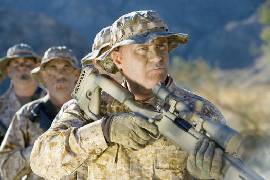 Mature soldier with troop carrying rifles on a mission