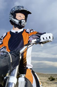 Low angle view of male bike rider riding motorbike against sky