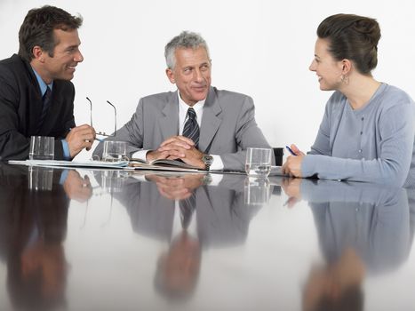 Three business colleagues having a discussion at conference table