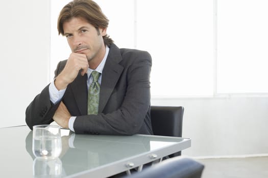 Business man sitting at conference table portrait
