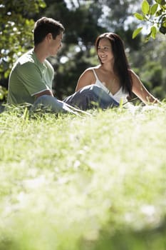 Young couple looking at each other while sitting in park