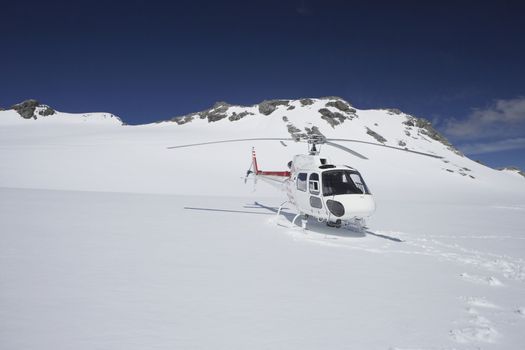 Helicopter Landing On Snowy Mountain Top