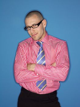 Portrait of a bald man in glasses with arms crossed against blue background
