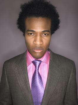 Portrait of a displeased afro businessman against purple background