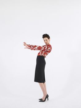 Full length side view of a young woman with hand gestures posing against white background