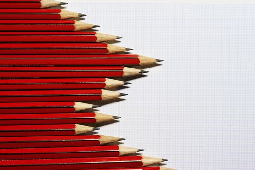 Pencils forming bar graph pattern on graph paper view from above