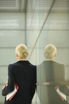Businesswoman Leaning Against Glass Partition