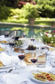 Table full of food and wine in backyard