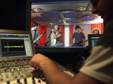 Band in recording studio with technician in foreground