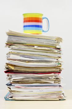 Coffee mug on stack of file folders