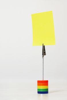 Reminder holding yellow adhesive note over white background