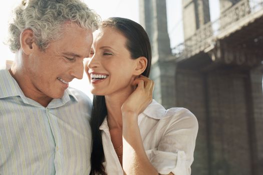 Caucasian couple smiling with bridge in the background