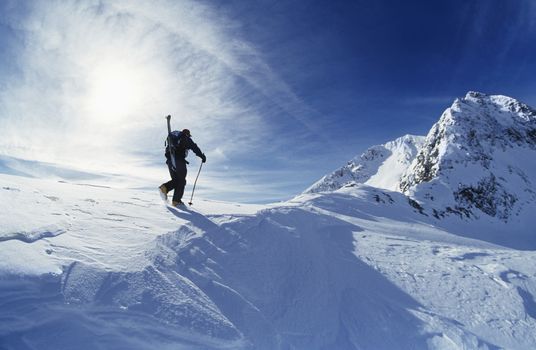 Skier hiking to mountain summit