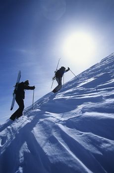 Skiers hiking to mountain summit