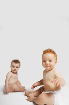 Portrait of cute babies sitting isolated on white background