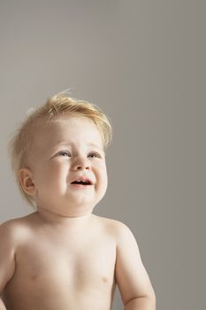 Cute boy crying isolated over gray background