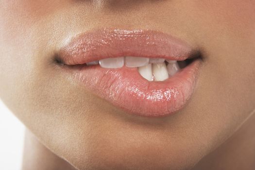 Macro view of a seductive woman biting her lip