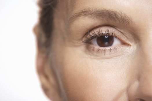 Detail shot of mature woman's eye over white background